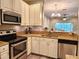 Well-lit kitchen with stainless appliances, granite counters, and stylish pendant lighting at 11246 Kapok Grand Cir, Madeira Beach, FL 33708