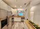 A bright kitchen with stainless appliances, granite countertops, white cabinets and wood look floors at 11246 Kapok Grand Cir, Madeira Beach, FL 33708