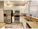 Updated kitchen featuring granite countertops, stainless steel appliances, and white cabinetry at 11246 Kapok Grand Cir, Madeira Beach, FL 33708
