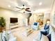 Comfortable living room with ceiling fan, plush seating, and view of stairs to the second story at 11246 Kapok Grand Cir, Madeira Beach, FL 33708