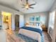 A beautifully decorated main bedroom with beach-themed art, ceiling fan, and wood-look flooring at 11246 Kapok Grand Cir, Madeira Beach, FL 33708