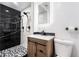 Modern bathroom with a walk-in shower featuring black and white tiles, and a stylish vanity with a light-up mirror at 11350 112Th Ave, Largo, FL 33778