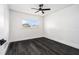 Minimalist bedroom with dark floors, a large window, and white walls offers a bright and airy space to relax at 11350 112Th Ave, Largo, FL 33778
