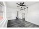 Bright bedroom featuring barn door closet, built-in shelf, ceiling fan and wood-look flooring at 11350 112Th Ave, Largo, FL 33778