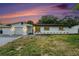 Charming single-story home featuring a well-manicured lawn and a neatly paved driveway at twilight at 11350 112Th Ave, Largo, FL 33778