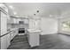 Modern kitchen features light gray cabinets, island with marble countertop, and black and white patterned backsplash at 11350 112Th Ave, Largo, FL 33778