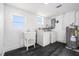 Functional laundry room with sink, washer, dryer, and water heater, all with wood-look flooring at 11350 112Th Ave, Largo, FL 33778