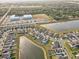 An aerial photograph of a residential area with a lake, community center and sports fields surrounded by lush greenery at 11476 Sage Canyon Dr, Riverview, FL 33578