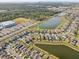 A serene aerial view of a neighborhood next to a lake, with nearby green spaces and community amenities at 11476 Sage Canyon Dr, Riverview, FL 33578