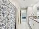 Bathroom boasts a double sink vanity and shower with stylish blue floral shower curtain at 11476 Sage Canyon Dr, Riverview, FL 33578