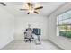 Well-lit bedroom with a ceiling fan, tile floor, and a view of the backyard at 11476 Sage Canyon Dr, Riverview, FL 33578
