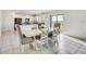 Bright dining area with white table, ornate chairs, and sliding glass doors to the backyard at 11476 Sage Canyon Dr, Riverview, FL 33578