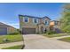 Two-story home boasts a spacious driveway, neutral tones, and well-maintained landscaping at 11476 Sage Canyon Dr, Riverview, FL 33578