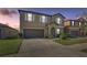 Two-story home boasts a spacious driveway, neutral tones, and well-maintained landscaping at 11476 Sage Canyon Dr, Riverview, FL 33578