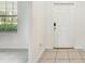 Inviting foyer with neutral tile flooring, white walls, and natural light shining through at 11476 Sage Canyon Dr, Riverview, FL 33578