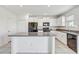 Spacious kitchen with white cabinets, granite counters, black appliances, and center island at 11476 Sage Canyon Dr, Riverview, FL 33578