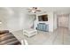 Open-concept living room featuring sleek tile flooring, a ceiling fan, and natural light at 11476 Sage Canyon Dr, Riverview, FL 33578
