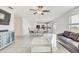 Open-concept living room featuring sleek tile flooring, a ceiling fan, and natural light at 11476 Sage Canyon Dr, Riverview, FL 33578