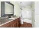 Bathroom featuring a vanity with granite top, tub-shower combo, and wood-look floors at 12107 Fox Bloom Ave, Gibsonton, FL 33534