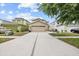 Charming two-story home with a beige exterior, a wide driveway, and well-maintained landscaping at 12107 Fox Bloom Ave, Gibsonton, FL 33534