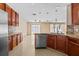 Well-lit kitchen featuring wood cabinets, granite countertops, stainless steel appliances, and tile flooring at 12107 Fox Bloom Ave, Gibsonton, FL 33534