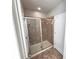 Modern bathroom features tiled shower with sliding glass doors and tiled floors at 12499 Longstone Ct, New Port Richey, FL 34655