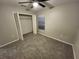 This cozy bedroom features plush carpet, a ceiling fan, and a convenient closet at 12499 Longstone Ct, New Port Richey, FL 34655