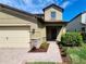 Inviting front exterior of a two-story home with a paved walkway and garden at 12499 Longstone Ct, New Port Richey, FL 34655