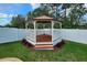 A fenced gazebo provides a cozy outdoor retreat in this landscaped yard at 12499 Longstone Ct, New Port Richey, FL 34655