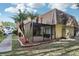 Angle view of the building's exterior showing palm trees, mulch beds, screened porch, and a portion of the walkway at 12736 Wood Trail Blvd, Tampa, FL 33625