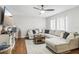 Inviting living room featuring wood floors, a comfortable sectional sofa, and a modern ceiling fan with light at 12736 Wood Trail Blvd, Tampa, FL 33625