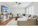 Inviting living room featuring wood floors, a comfortable sectional sofa, and a modern ceiling fan with light at 12736 Wood Trail Blvd, Tampa, FL 33625