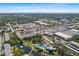 Aerial view of a community with a pool, pond, and nearby commercial areas at 14130 Rosemary Ln # 1202, Largo, FL 33774
