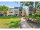 Well-maintained condo building with lush landscaping and a sidewalk at 14130 Rosemary Ln # 1202, Largo, FL 33774