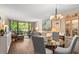 Bright living room with hardwood floors, art, and view of nature through large windows at 14130 Rosemary Ln # 1202, Largo, FL 33774