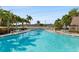Community outdoor swimming pool with chairs and tables, ideal for relaxation at 14130 Rosemary Ln # 1202, Largo, FL 33774