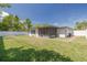 Spacious backyard offering a serene retreat with lush green grass, an enclosed patio and a well-maintained privacy fence at 1717 Thames St, Clearwater, FL 33755