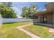 A charming backyard with a screened-in porch with a wood ceiling, a well maintained privacy fence, and lush green grass at 1717 Thames St, Clearwater, FL 33755