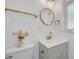 Charming bathroom with gray vanity, gold fixtures, round mirror, and decorative accents, offering a cozy ambiance at 1717 Thames St, Clearwater, FL 33755