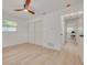Well-lit bedroom with light wood flooring, ceiling fan, closet, and bright white walls at 1717 Thames St, Clearwater, FL 33755