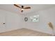 A cozy bedroom featuring light wood floors, a ceiling fan, and ample natural light through a bright window at 1717 Thames St, Clearwater, FL 33755