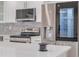 Modern kitchen with stainless steel appliances, sleek white cabinets, and a gray backsplash, offering style and functionality at 1717 Thames St, Clearwater, FL 33755