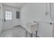 Bright laundry room featuring a utility sink, gray tile floor, and white walls for a clean and functional space at 1717 Thames St, Clearwater, FL 33755