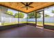 Enclosed patio showcasing a wood ceiling, ceiling fan, screen windows, and backyard views at 1717 Thames St, Clearwater, FL 33755