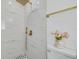 Stylish shower featuring marble-look tiles, gold fixtures, and a rainfall showerhead for a spa-like experience at 1717 Thames St, Clearwater, FL 33755