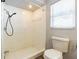 Bathroom featuring a shower, toilet, and window for natural light at 1760 Sharondale Dr, Clearwater, FL 33755
