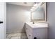 Simple bathroom showcasing a vanity with a mirror, gray walls, and marble-look tile flooring at 1760 Sharondale Dr, Clearwater, FL 33755