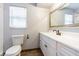 Bathroom featuring a toilet, large mirror, and vanity with white cabinets at 1760 Sharondale Dr, Clearwater, FL 33755