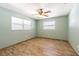 Bedroom featuring wood look floors, ceiling fan, and two windows for natural light at 1760 Sharondale Dr, Clearwater, FL 33755