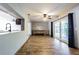 Open-concept living room with sliding glass doors and wood-look flooring at 1760 Sharondale Dr, Clearwater, FL 33755